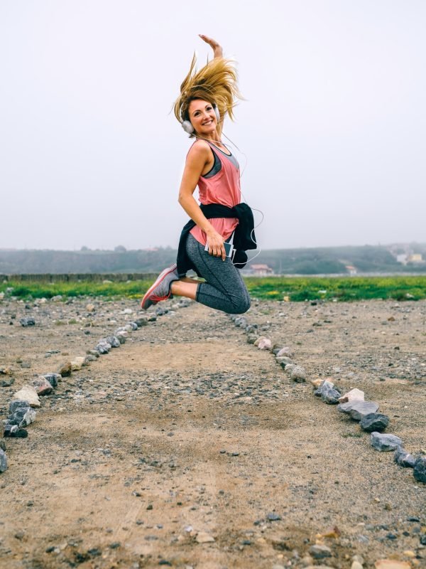 Young sportswoman jumping on the road